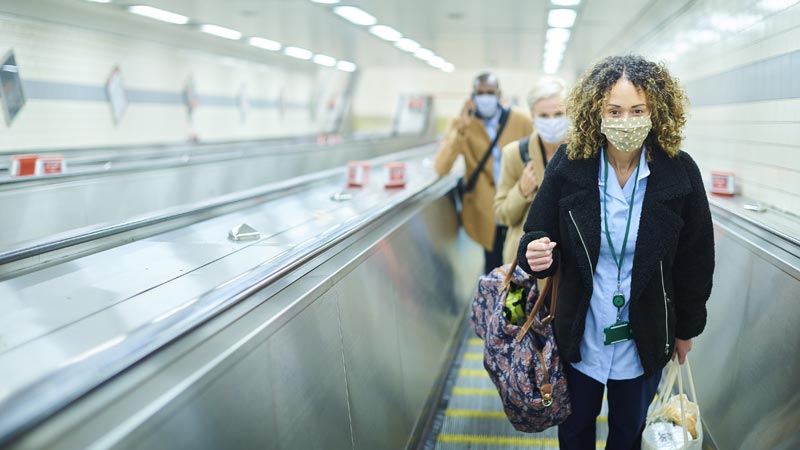 mulher usa máscara no interior de uma estação de metro